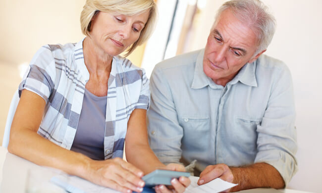 a man and woman, calculating retirement assets