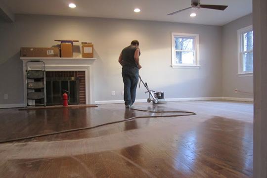 A man refinishing wood floors