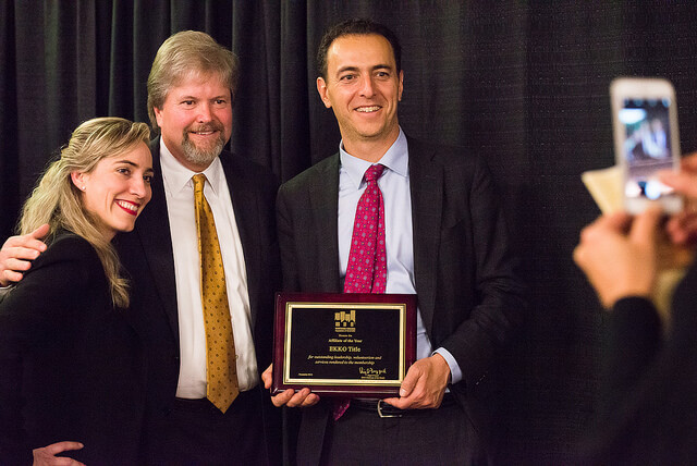 A man showing off his Award plaque