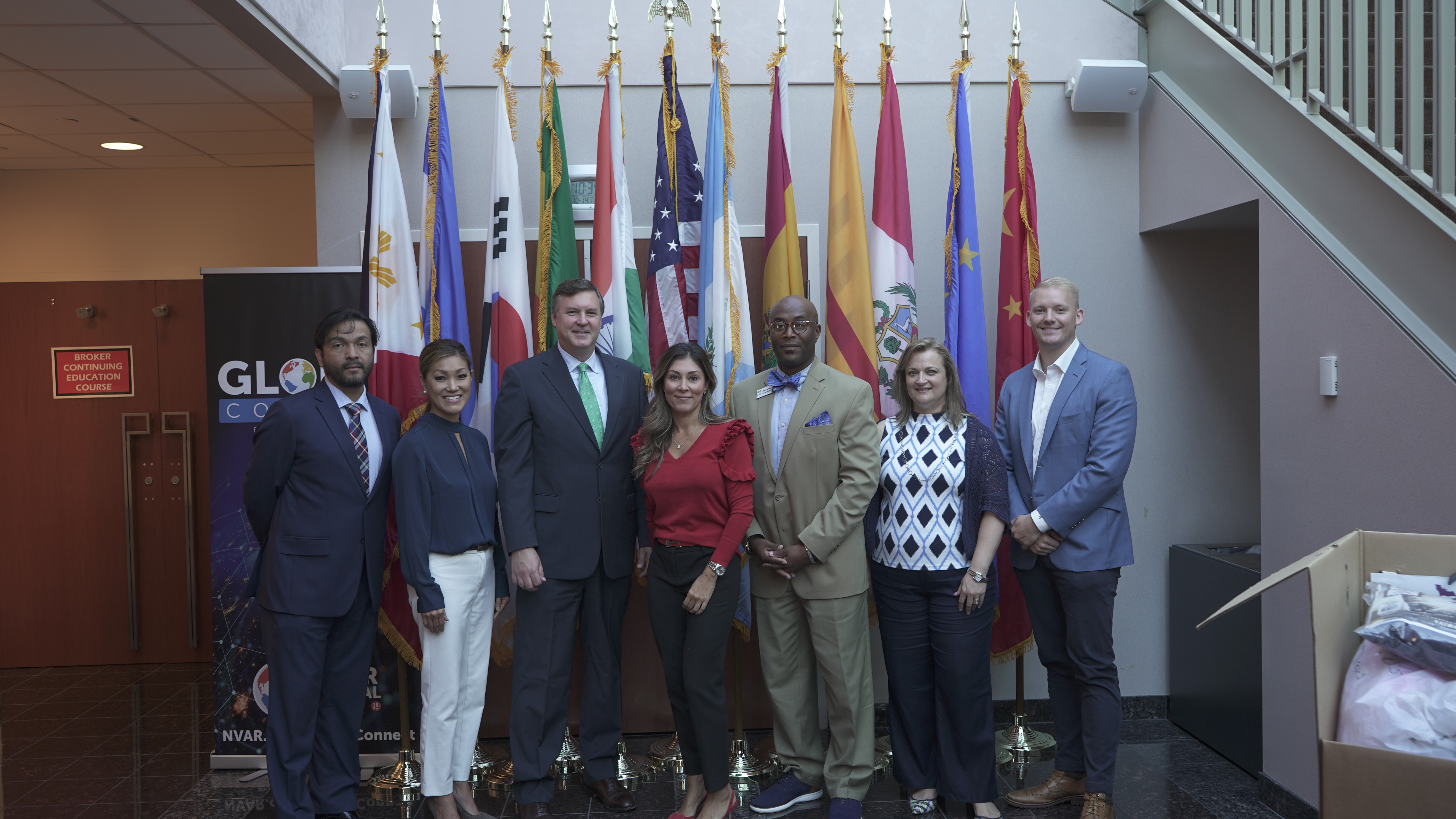 Board members in front of flags