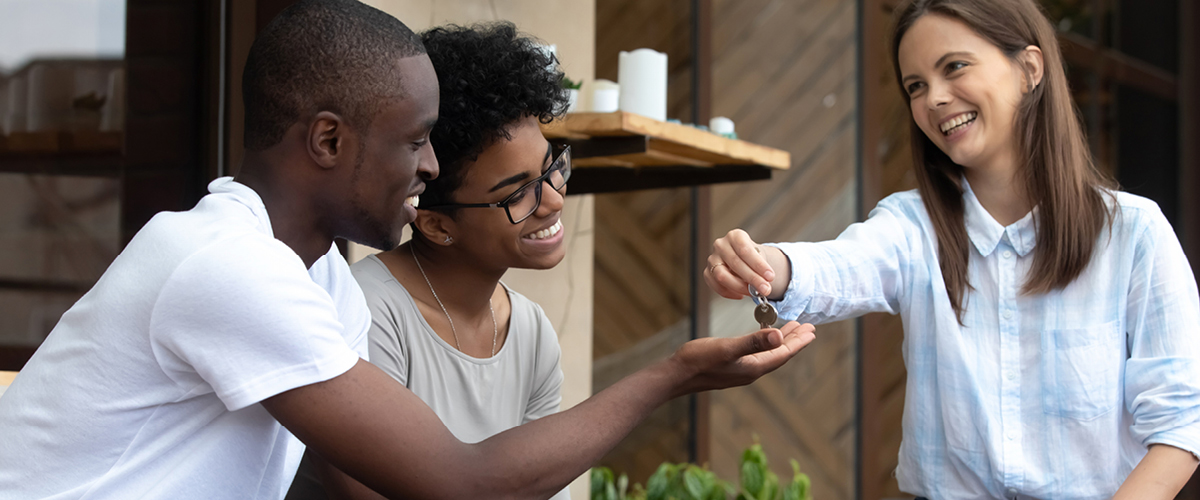 woman giving keys to couple