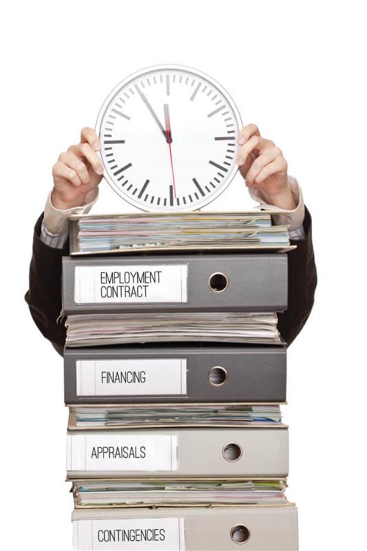 A clock placed on a pile of folders