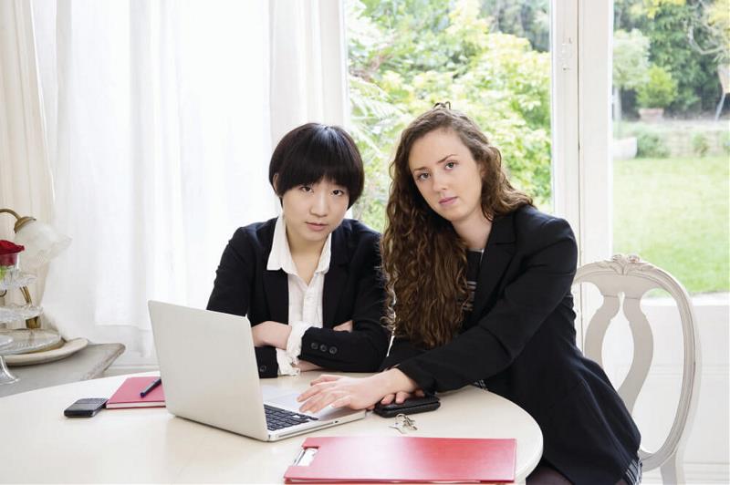 2 ladies pose with a laptop