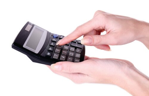 Fingers holding and pressing a calculator