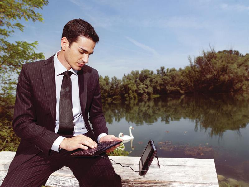 A tech savvy guy by a pond