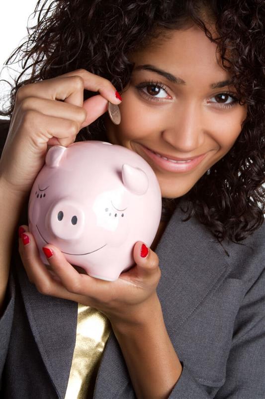 girl dropping a coin in a piggy bank