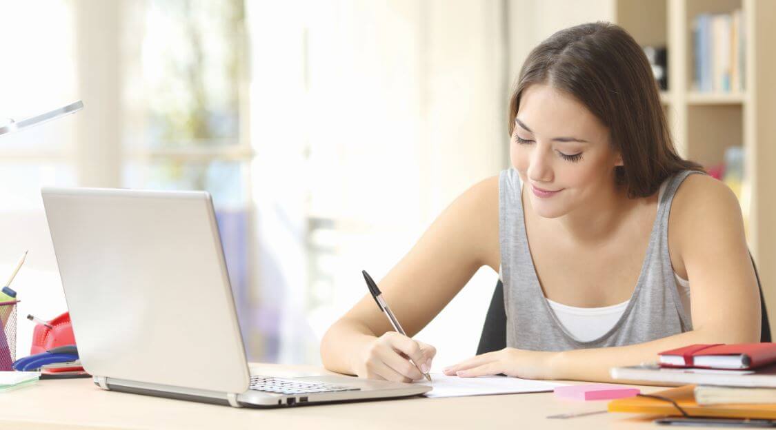 a lady using her pen and a laptop