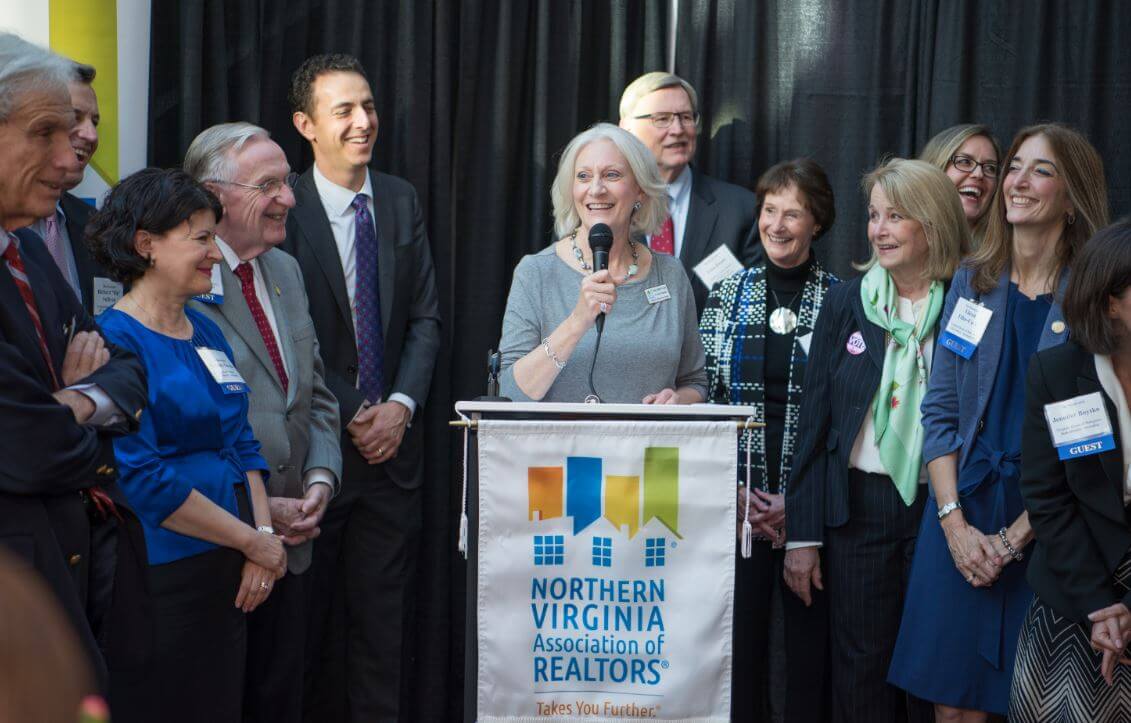 Senior Vice President of Public & Government Affairs Mary Beth Coya (at podium) shares a light-hearted moment with legislators after thanking them