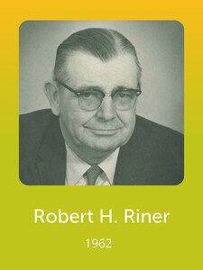 The image shows a black-and-white portrait of a person wearing glasses and a suit, with the name "Robert H. Riner" and date "1962."