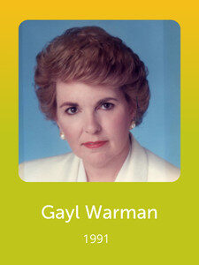 A person in a formal outfit poses against a blue background. The image includes the text "Gayl Warman 1991" on a yellow-green gradient.