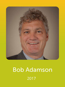 A person with curly hair is smiling against a plain background. The image includes text displaying the name "Bob Adamson" and the year "2017."