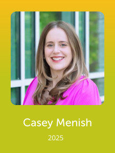 A smiling person in a pink outfit stands in front of a glass window. The text reads "Casey Menish 2025" against a yellow-green background.