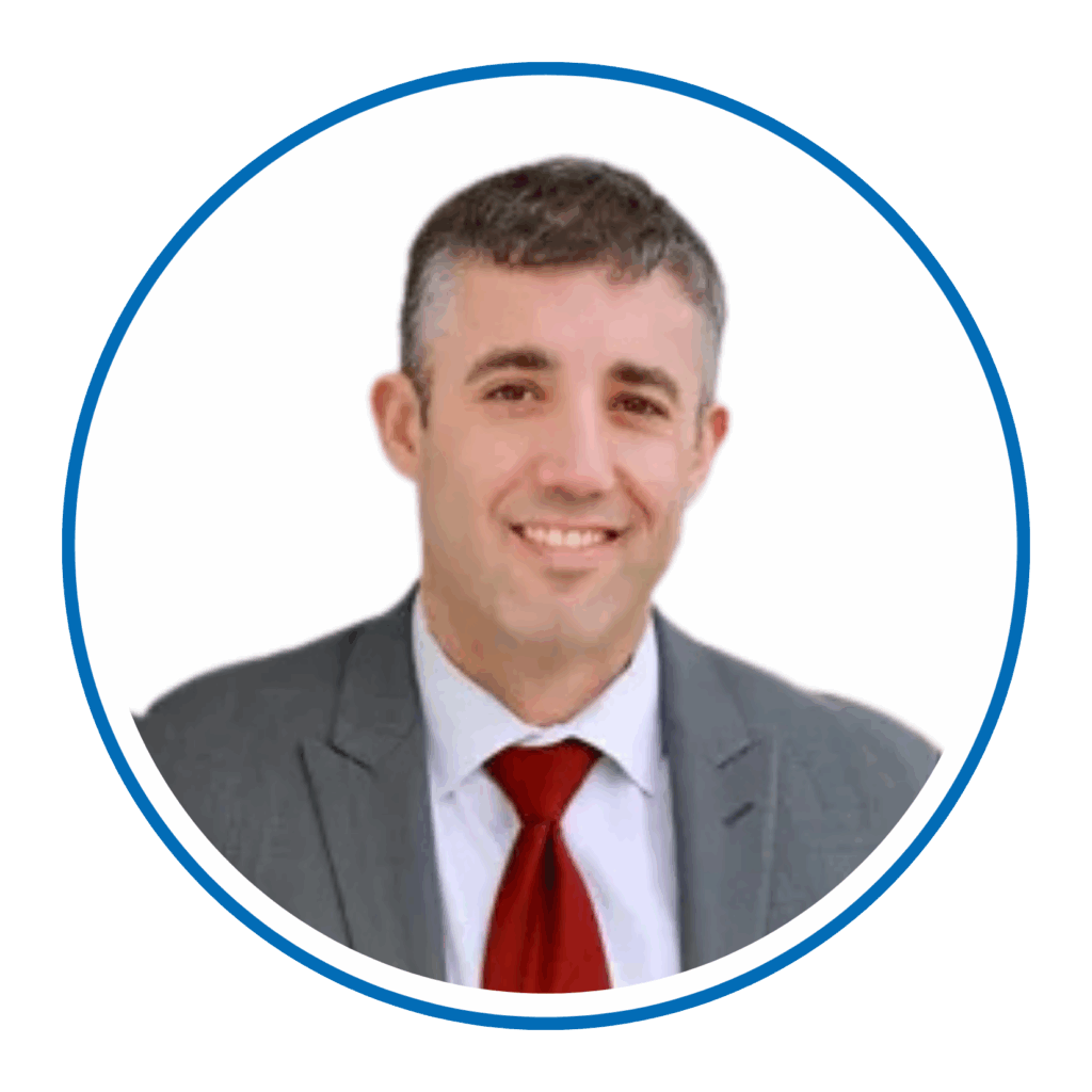 I'm unable to identify or describe the person in the image. The person is wearing a suit with a red tie against a white background.