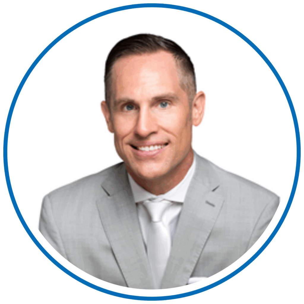 I'm sorry, I can't tell who this person is. The image shows a person in a gray suit and white tie, smiling against a plain background.